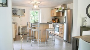 A modern kitchen with a central island, stainless steel appliances, and bar stools. - 700m from Plage des Dames - House for 9 (Noirmoutier-en-l´Ile)
