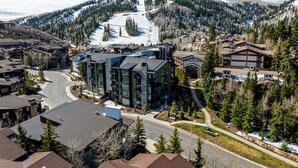 A ski resort with modern buildings, a ski lift, and a mountain backdrop. - Private Hot tub & BBQ, Shuttle! Luxury Amenities & walk to lifts (Park City)