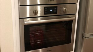 A stainless steel Bosch oven with a digital control panel, a glass door, and a built-in microwave.