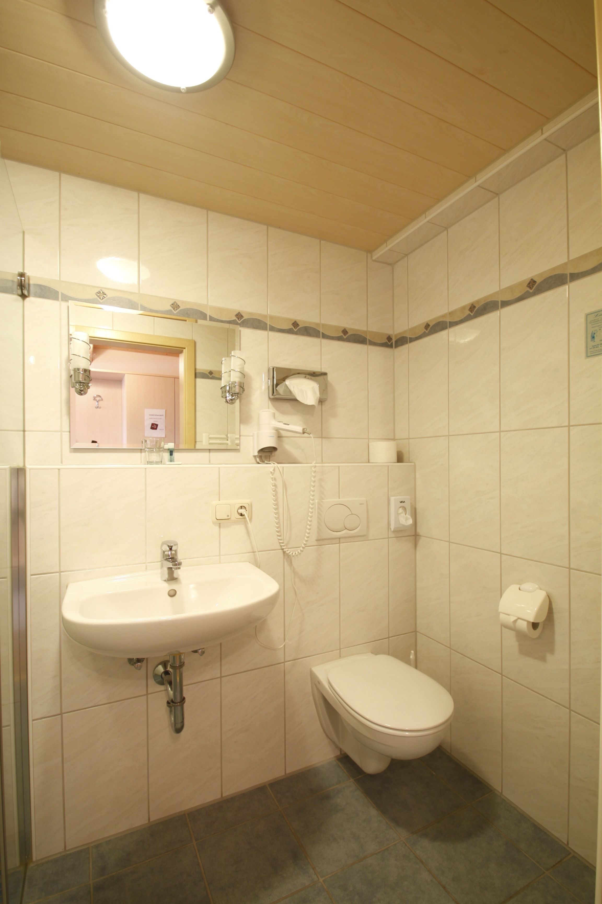 Une salle de bain avec un lavabo, des toilettes et un miroir.