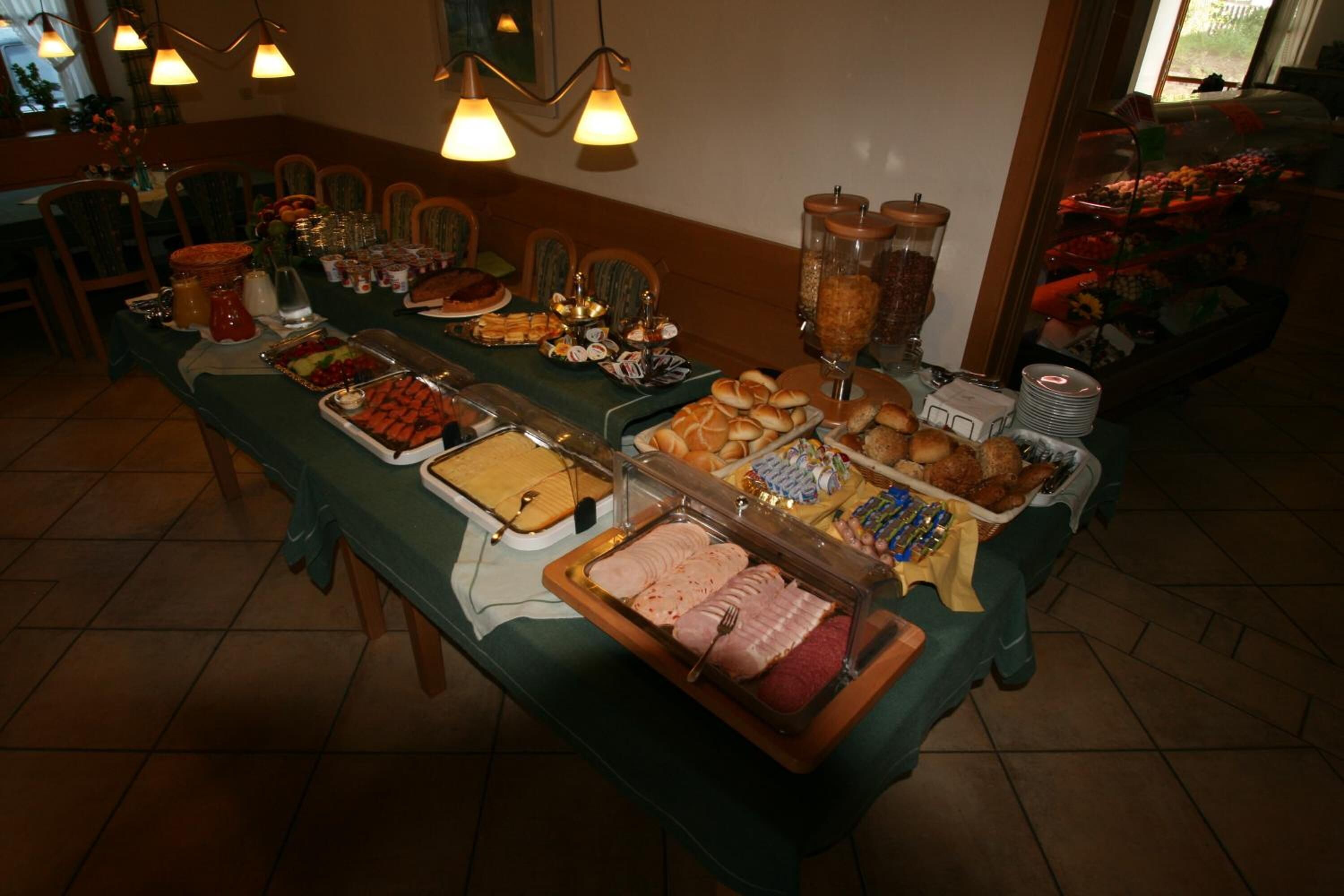 A buffet table with various food items and a glass display case.
