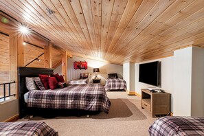 Ein gemütliches Schlafzimmer mit zwei Betten, einem Fernseher und einem Schreibtisch.