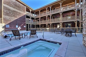 Un área de piscina con sillones de descanso y un jacuzzi.
