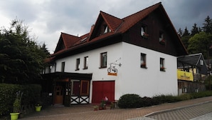 A two-story building with a red-tiled roof, a bicycle sign, and a sign for 'Wattler Schause'. - Radler-Scheune Thüringen (Friedrichroda)