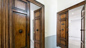 A hallway with wooden doors and a tiled floor.