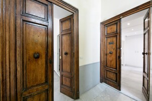 Un couloir avec des portes en bois et un sol carrelé.