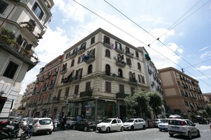 Un immeuble à plusieurs étages, avec un commerce au rez-de-chaussée et des appartements aux étages supérieurs.