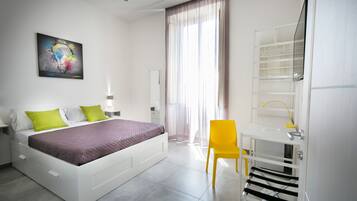 Una camera da letto moderna con un letto, una scrivania e una sedia.