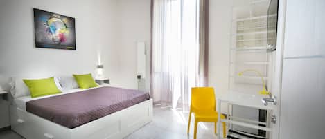 A modern bedroom with a bed, a desk, and a chair.