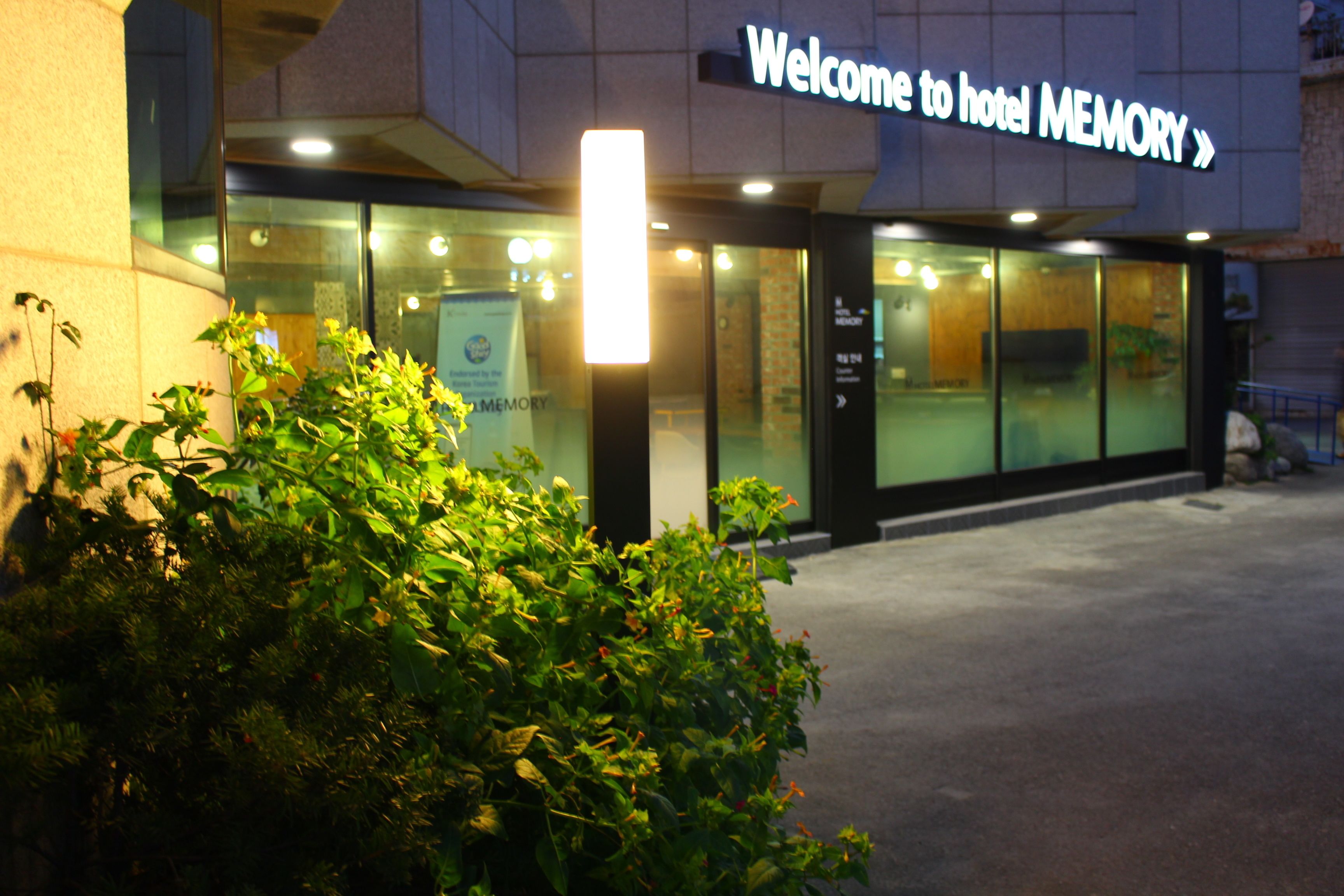 A hotel entrance with a sign reading "Welcome to hotel MEMORY".