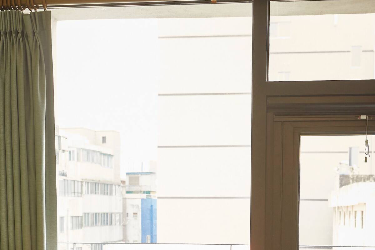 Une chambre à coucher avec un lit, une fenêtre et une porte donnant sur un balcon extérieur.