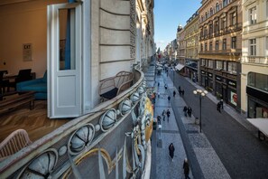 A street-level view of a building with a balcony, cobblestone street, and pedestrians. - Old Town - Aparthotel Michalska (Prague)