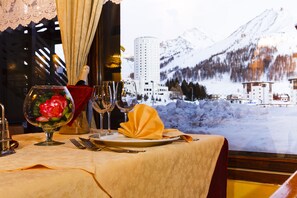 A table set for a meal with a view of a snowy mountain landscape. - Hotel Biancaneve (Sestriere)