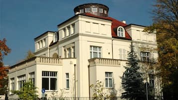Un grand bâtiment historique doté d’une tourelle imposante et de nombreuses fenêtres.