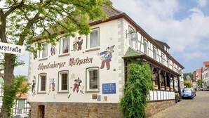 A traditional half-timbered building with a sign for 'Schwäbischer Malkastener' and a view of the street. - Hotel Schwalenberger Malkasten (Schieder-Schwalenberg)