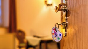 A door with a brass handle and a keychain with colorful tags. - Hotel Schwalenberger Malkasten (Schieder-Schwalenberg)