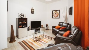 Un salon moderne avec un canapé, un téléviseur et des objets de décoration.
