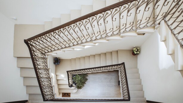 Un escalier orné d’une rampe en métal décorative et d’une pancarte de bienvenue.