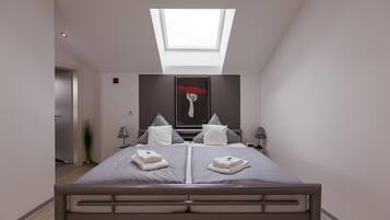 A modern bedroom with a skylight, a bed with pillows, and a painting on the wall.