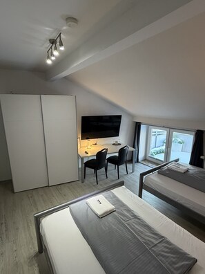 A compact room with a bed, a desk with a chair, a TV, and a wardrobe. - Hotel Rühen 24-hour check-in, free parking, guest kitchen (Rühen)