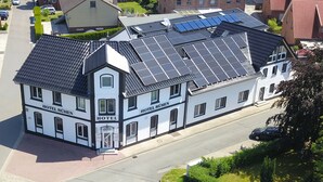 A hotel with solar panels on the roof, a prominent entrance, and a street view. - Hotel Rühen 24-hour check-in, free parking, guest kitchen (Rühen)