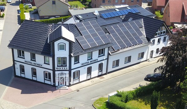 A hotel with solar panels on the roof, a prominent entrance, and a street view. - Hotel Rühen 24-hour check-in, free parking, guest kitchen (Rühen)