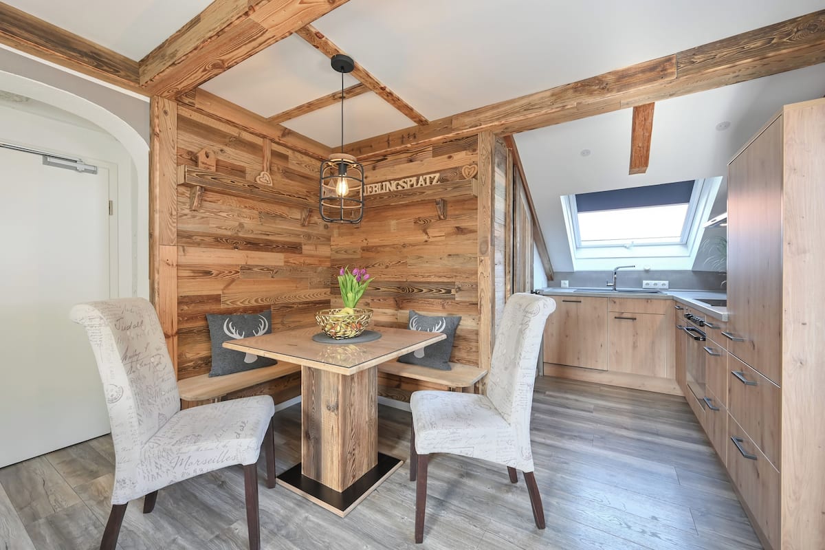 A cozy kitchen with wooden walls, a central island, and a skylight.