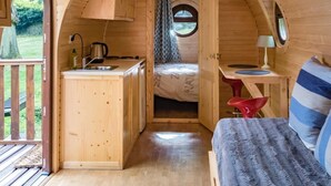 A cozy, wooden interior with a kitchen, a bed, and a small table. - Domaine de Marguerite (Janvry)