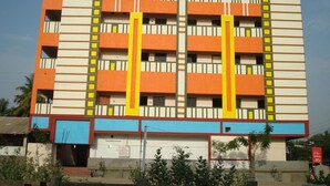 A multi-story building with a modern architectural design, featuring a series of balconies and windows. - Hotel Bhavani Grand (Nidadavolu)