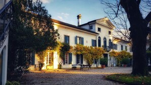A historic building with a cobblestone courtyard, a bench, and a statue. - Villa di Tissano (Santa Maria la Longa)