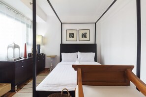 Relax in a serene space with a large bed, framed artworks, and a stylish dresser.