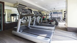 Una palestra con tapis roulant, cyclette e pesi liberi.