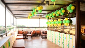 A restaurant with outdoor seating, a covered area, and a view of the city.