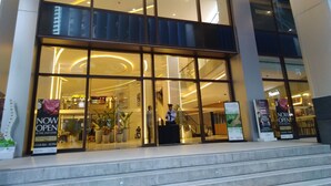 A modern building with large glass windows and a staircase leading to the entrance.
