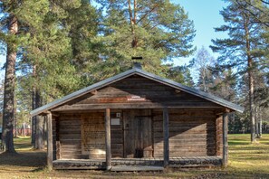 A wooden cabin with a sign reading "NORRA ELDPALLKOJIAN".