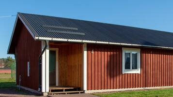 A red building with a metal roof and a wooden door.