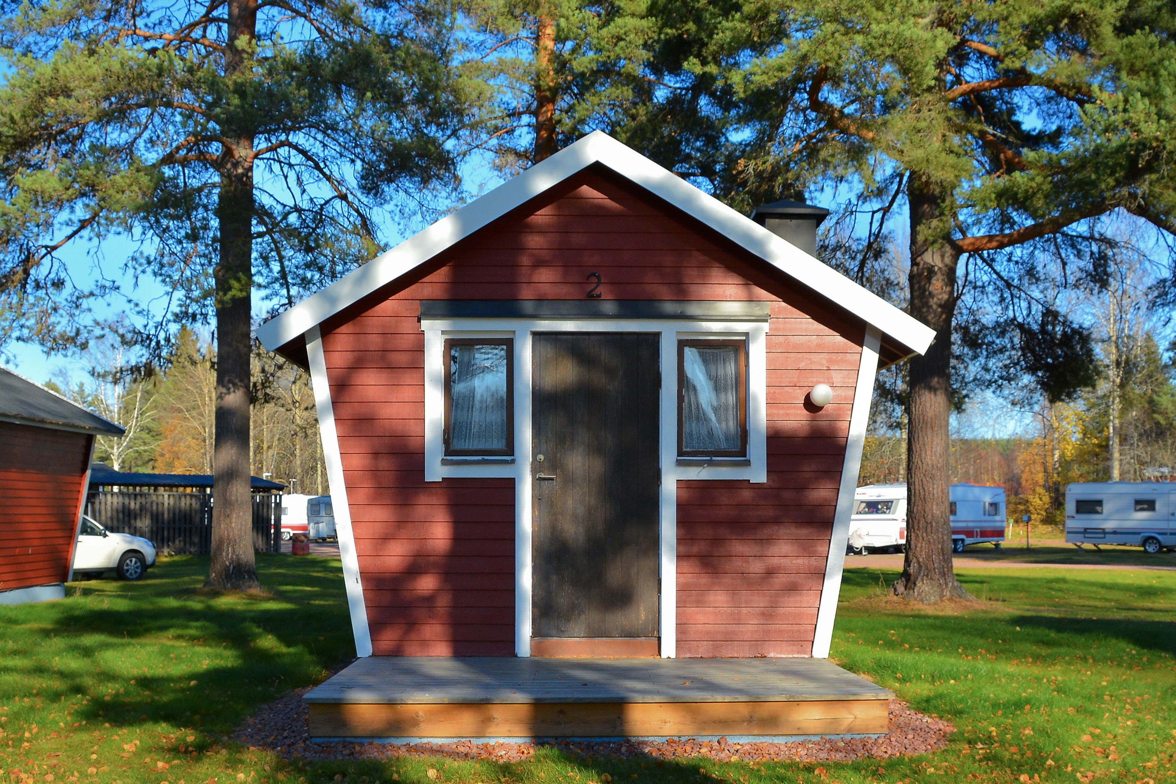 A small, single-story cabin with a gabled roof, a front door, and two windows.