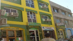 Un edificio de varios pisos que alberga diversos comercios, incluyendo un hotel, un bufete de abogados y una cafetería.