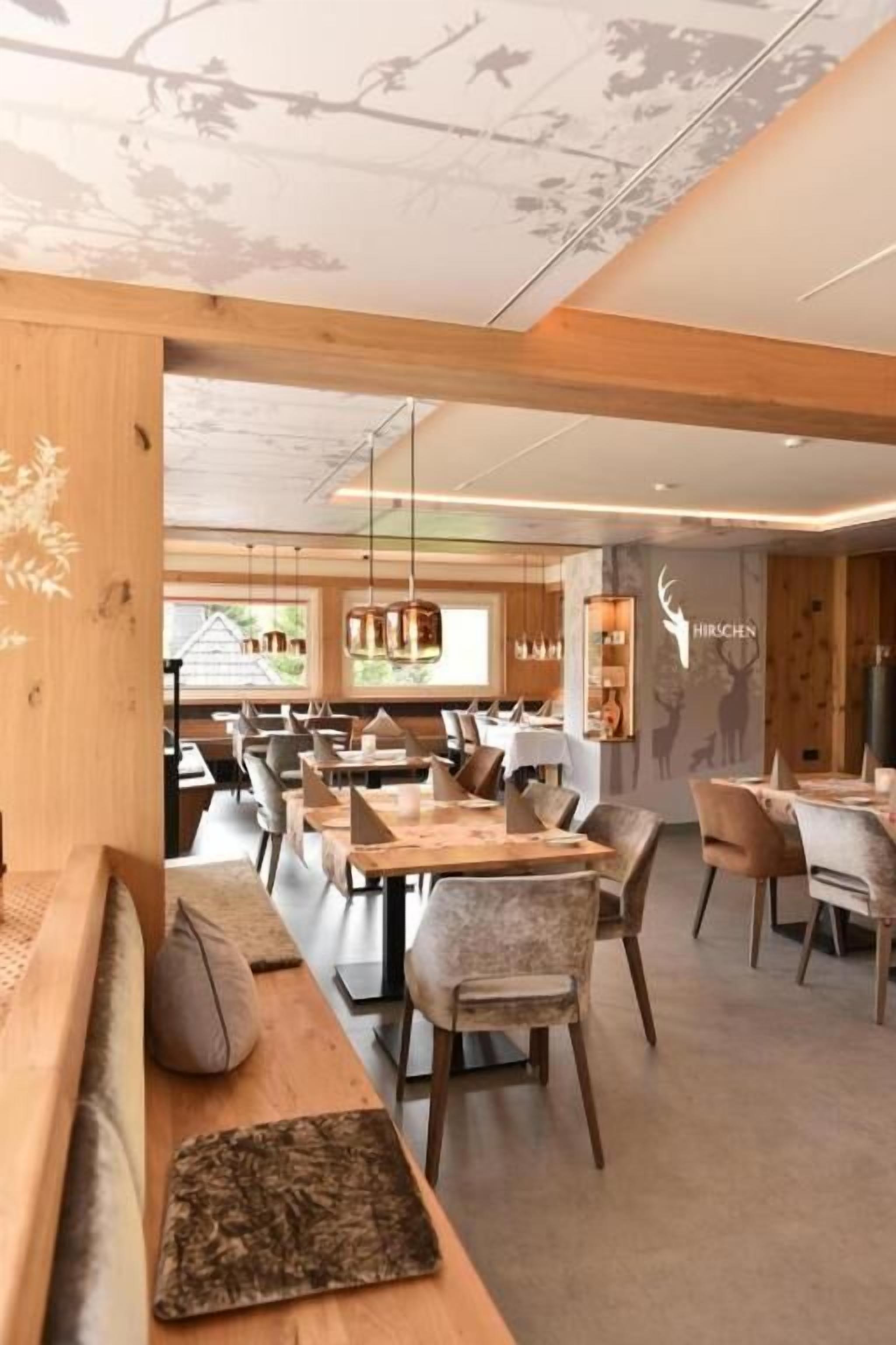 Un restaurante con vigas de madera, mesas y sillas.