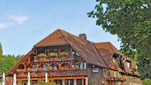 A traditional wooden building with a balcony, flower boxes, and a sign indicating it is a restaurant. - Gasthof Hotel Hirschen (Schluchsee)