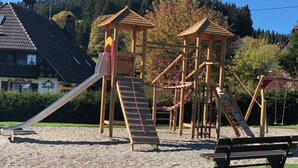 A playground with a slide, climbing structures, and a bench. - Gasthof Hotel Hirschen (Schluchsee)