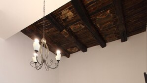 A room with a bed, a table with chairs, a chandelier, and a wooden cabinet. - Napolipietrasanta LT (Naples)