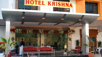 Entrada de un hotel con un cartel que dice "HOTEL KRISHNA".