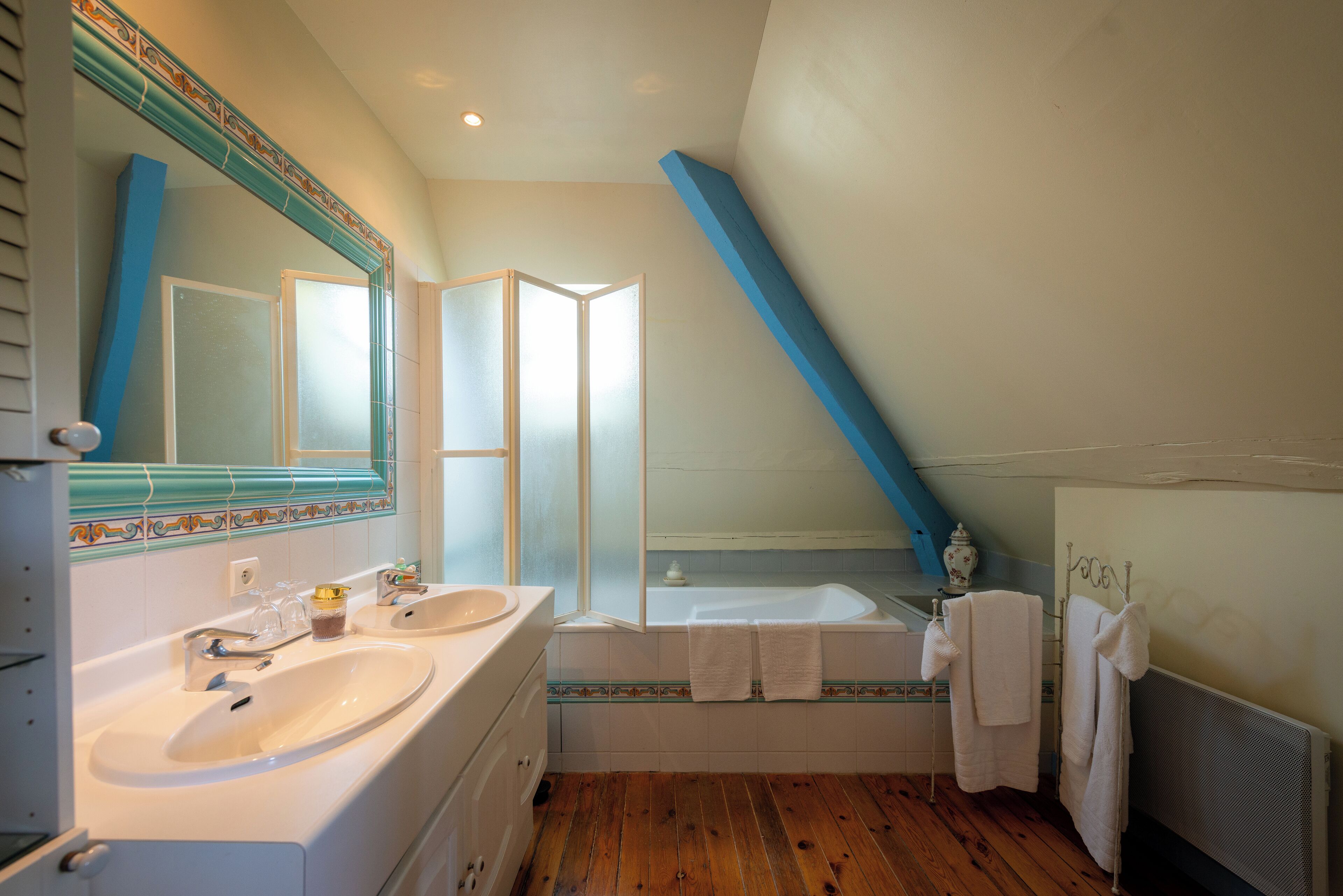 A bathroom with two sinks, a bathtub, and a large mirror.