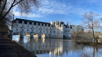 Un edificio histórico con varios arcos sobre un río, reflejado en el agua.