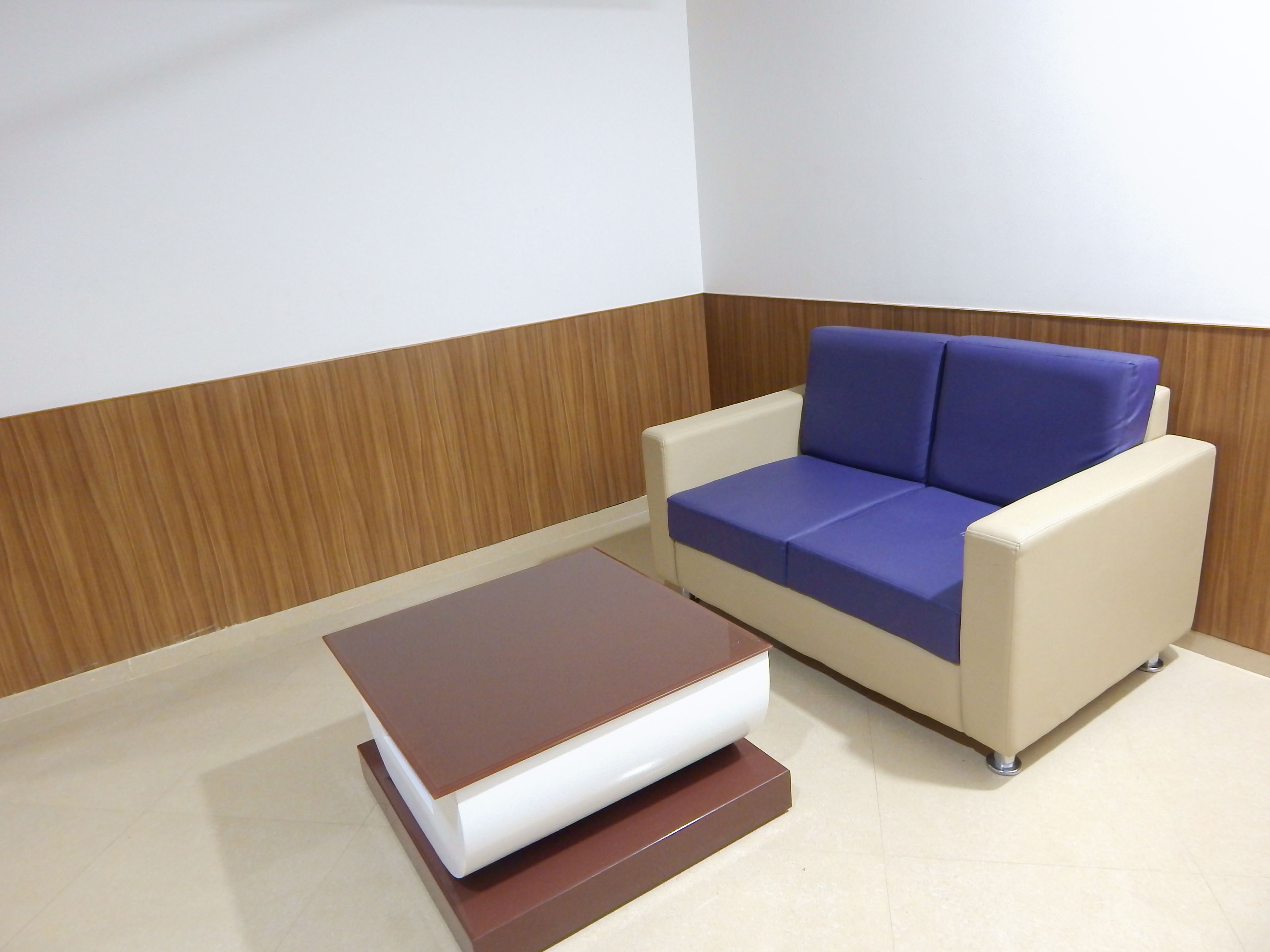 A modern room with a white sofa and a brown ottoman.
