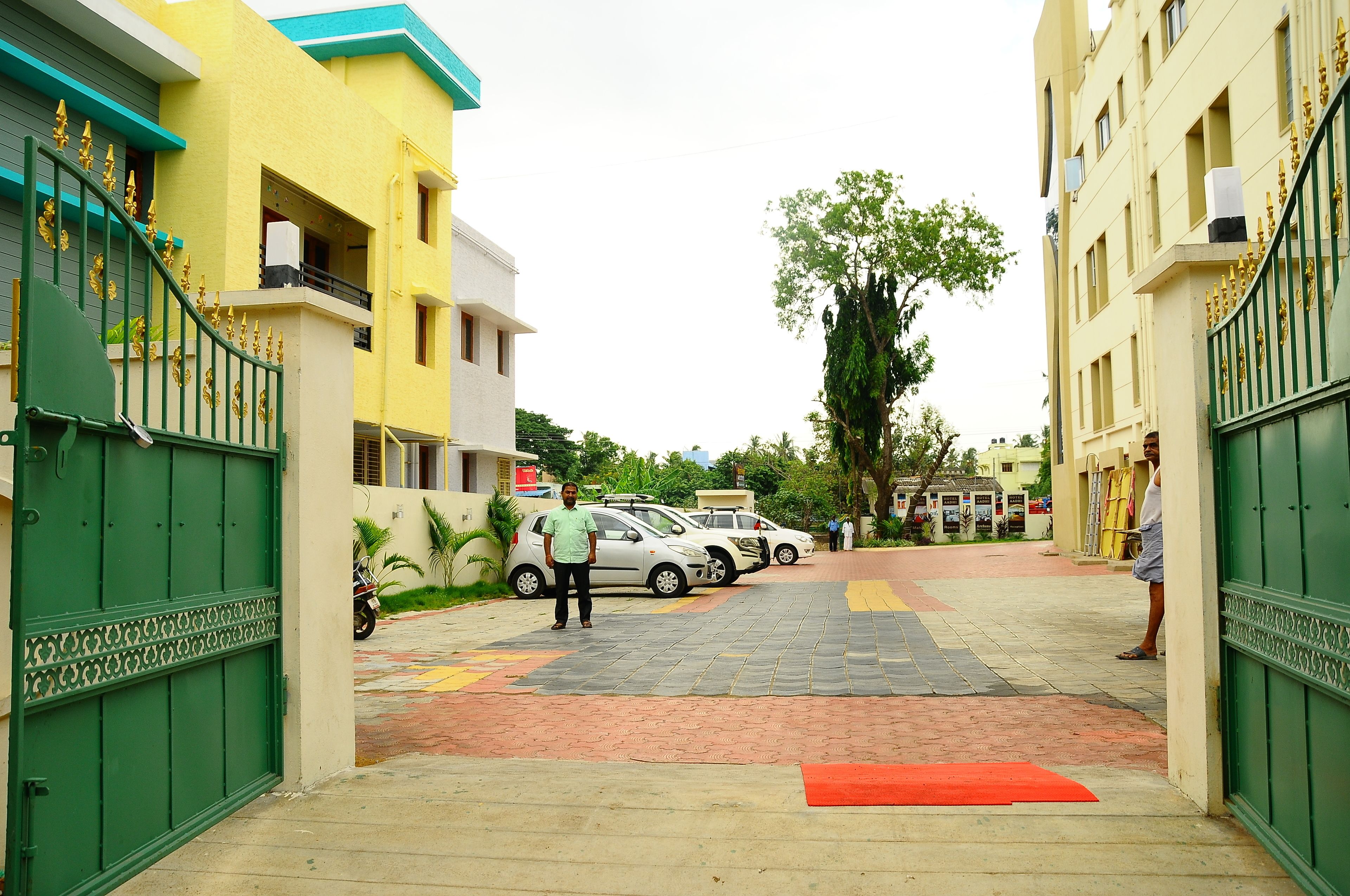 Una calle residencial con coches estacionados y una entrada protegida por un muro.