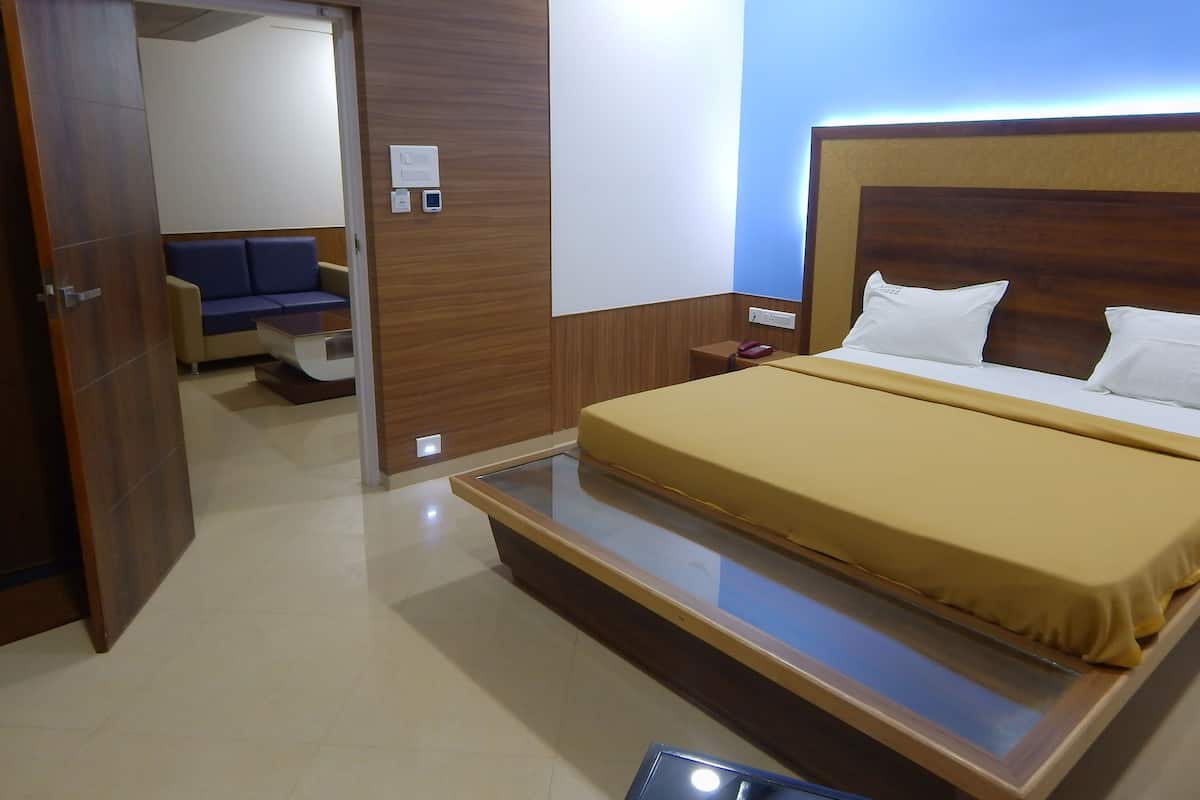 A hotel room with a bed, bedside table, and a blue wall.