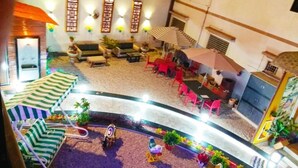 A spacious indoor area with a curved seating arrangement, a small fountain, and several potted plants. - Hotel Royal (Diu)