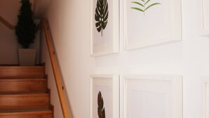 Una escalera de madera con barandilla que conduce a una plataforma con una planta en maceta.